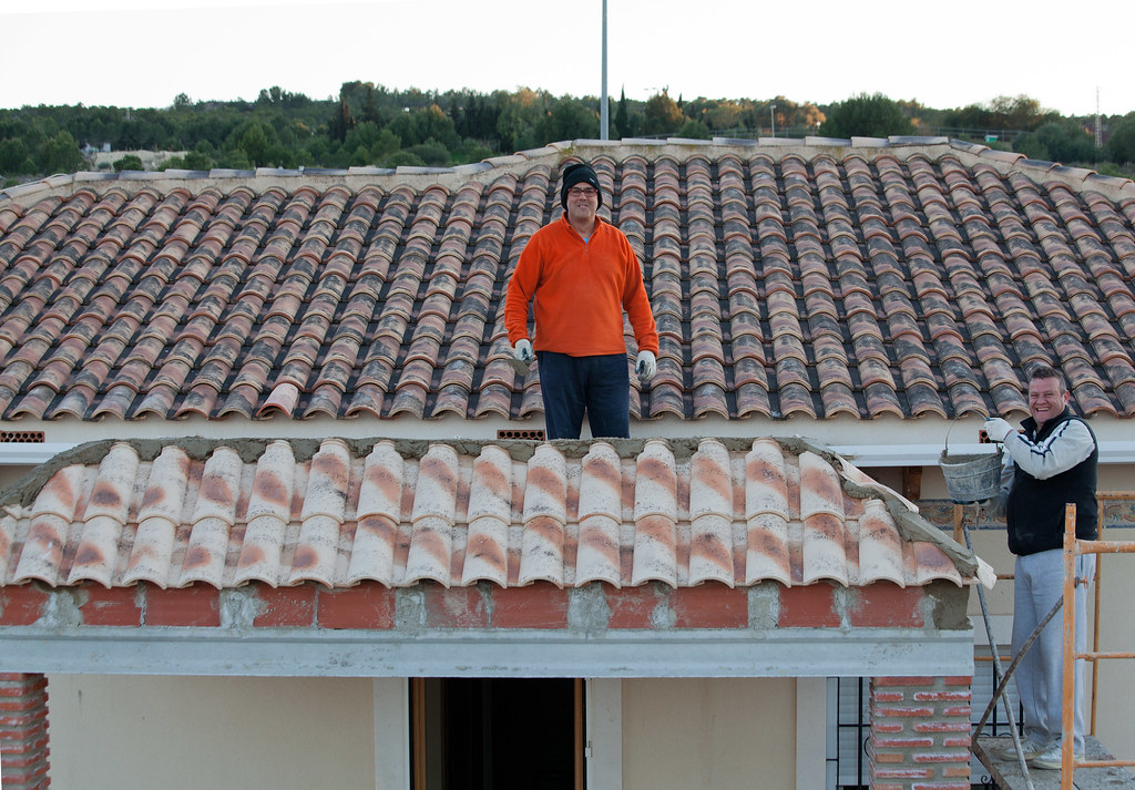 Roofers laying terracotta roof tiles